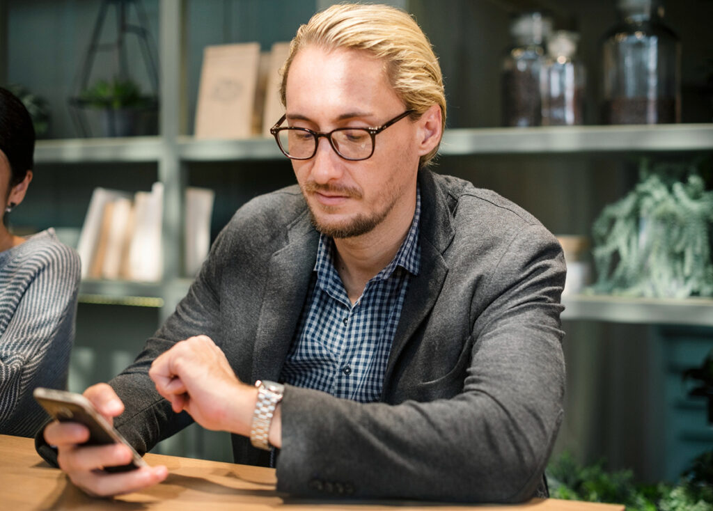 Man working on his phone, communicating with multiple different marketing agencies 